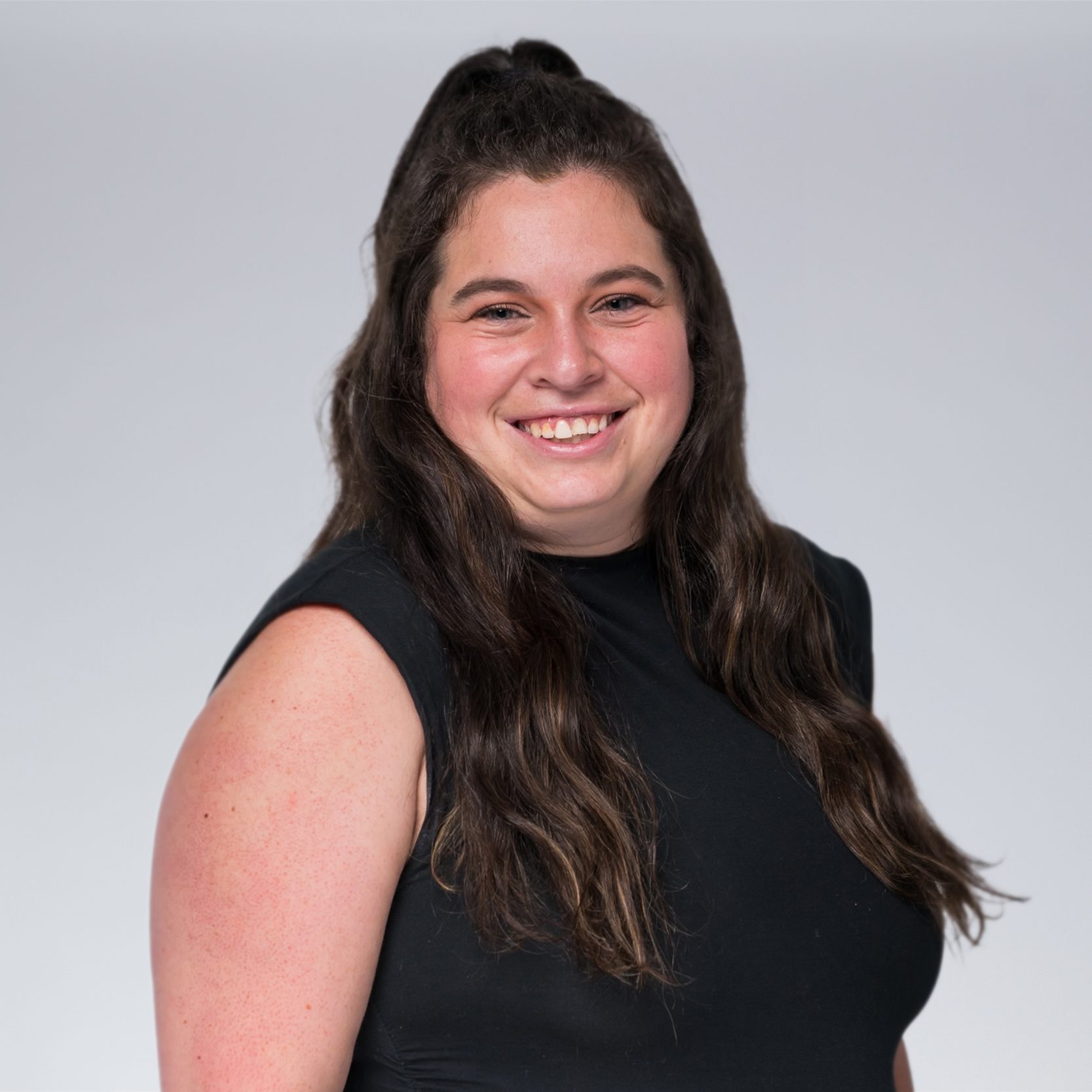 A diverse crowd of people celebrating at a concert, raising their hands and cheering.
